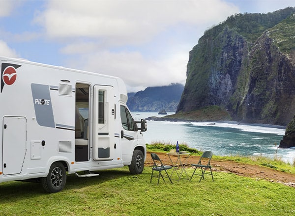 Camping-car profilé Pilote à l'étape, au bord d'une falaise surplombant la mer.